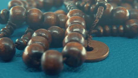 Macro-pan-shot-of-a-wooden-round-beads-necklace-with-coin-medallion