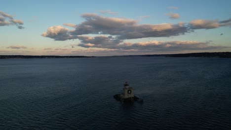 A-high-angle,-aerial-view-of-the-Huntington-Harbor-Lighthouse-on-Long-Island,-NY-at-sunset,-with-a-Christmas-wreath