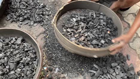 Close-up-shot-of-a-worker-sorting-dust-from-coal-before-been-used-in-a-workshop-in-Dhanbad,-Jharkhand,-USA-at-daytime