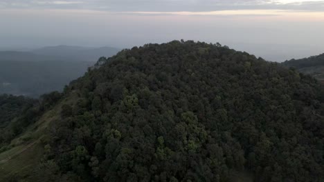 Reveal-drone-shot-of-a-forest-with-fog-and-haze-in-the-mountain-of-Thailand