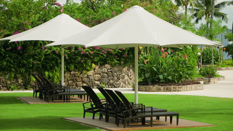 Tumbonas-Y-Sombrillas-Vacías-Al-Aire-Libre-En-El-Jardín-Paisajístico-De-Un-Hotel-Y-Resort-De-Lujo-En-Cebu,-Filipinas