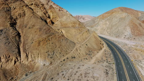 California-State-Route-58-winding-through-the-Mojave-Desert's-rugged-canyons---descending-aerial-view