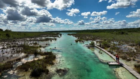 Aerial-view-over-people-swimming-and-enjoying-the-day-at-the-Bacalar-rapids,-in-sunny-Mexico