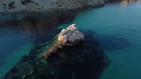 Aerial-drone-orbiting-around-white-rock-formation-in-South-Sardinia-at-sunset