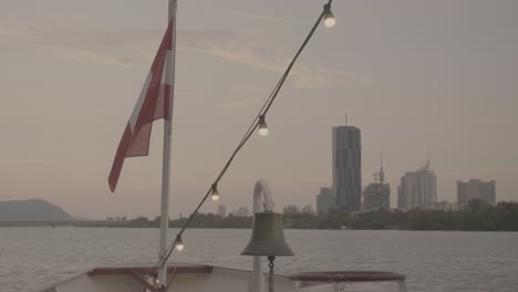 Österreich-Flagge-Auf-Einem-Donauschiff-Weht-Im-Wind-Mit-Dem-DC-Turm-Im-Hintergrund