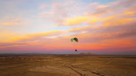 Powered-paragliding-over-the-Mojave-Desert-Landscape-during-an-epic-sunset---aerial-drone-follow