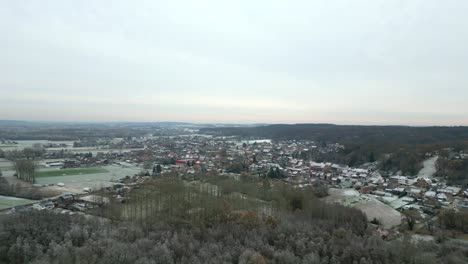 Aerial-footage-of-a-small-village-in-the-beginning-of-winter,-covered-in-first-snow