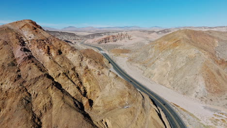 Hohe-Luftaufnahme-Des-Kalifornischen-Highway-58-In-Der-Zerklüfteten-Landschaft-Der-Mojave-Wüste