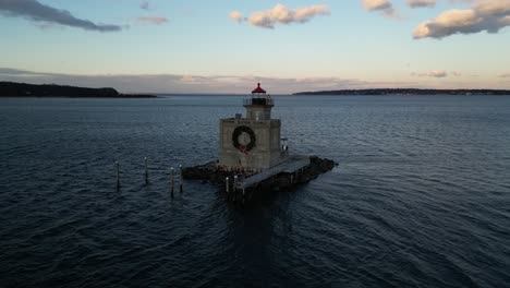 Eine-Luftaufnahme-Des-Leuchtturms-Huntington-Harbour-Auf-Long-Island,-New-York-Bei-Sonnenuntergang,-Mit-Einem-Weihnachtskranz