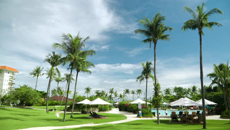 Luxuriöses-Tropisches-Shangri-la-Mactan-Resort-Hotel-Mit-Hohen-Palmengrünen-Rasenflächen-Und-Menschen,-Die-Sich-Tagsüber-Am-Pool-Entspannen