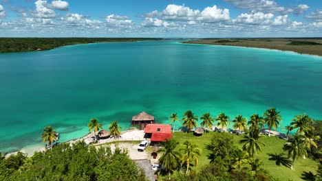 Aerial-view-over-a-paradise-resort-at-the-sunny-Bacalar-lagoon,-in-Mexico
