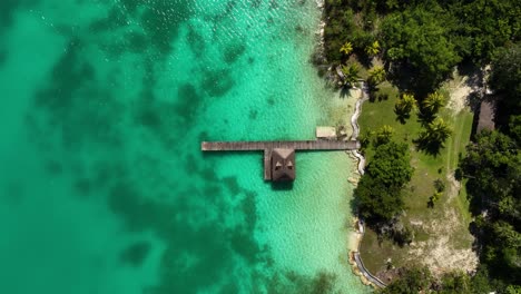 Aerial-view-above-a-wooden-pier-at-the-Bacalar-lagoon,-in-Mexico---birds-eye,-drone-shot