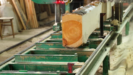 Lumbering-in-sawmill-with-bandsaw-on-a-stationary-table,-double-sided-log-sawing
