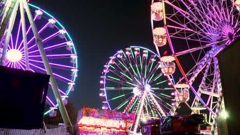 Multiple-Ferris-Wheels-Spinning-at-Manufacturer-of-Fairground-Attractions-During-Nighttime