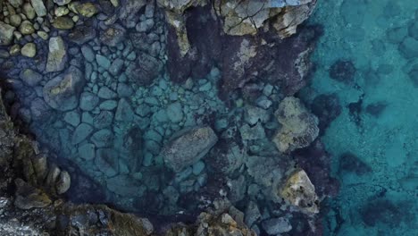 4K-aerial-ocean-coast-in-Sardinia,-Mussareddu-with-stones-and-clear-water