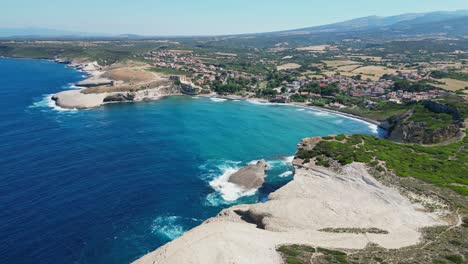 S'-Archittu-beach-town-and-rocky-cliffs-at-west-coast-of-Sardinia,-Italy---4k-Aerial