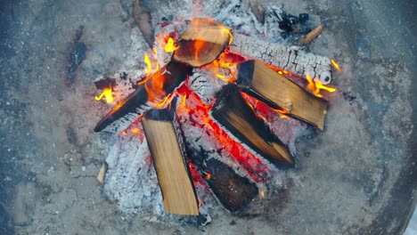 Top-down-high-angle-close-up-of-outdoor-fire-pit,-flames-and-burning-wood