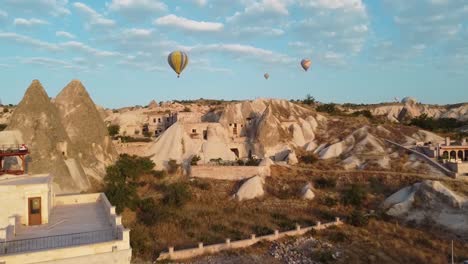 Balloons-flying-above-Goreme-at-sunrise-in-Cappadocia,-Turkey
