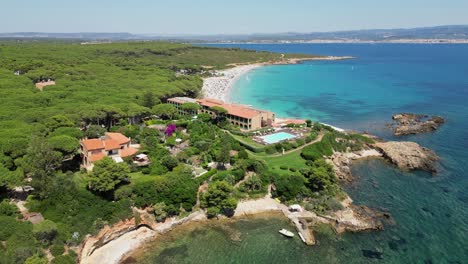 Luxury-beach-hotel-resort-at-Cala-Spinosa-Beach,-Sardinia,-Italy---4k-Aerial