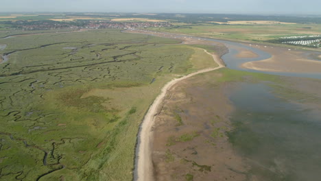 Establishing-Drone-Shot-Tilting-Up-to-Reveal-Wells-Next-The-Sea-Coastal-Town-with-Creek-and-Salt-Marsh-in-North-Norfolk-UK-East-Coast