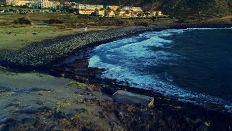 Couple-Standing-On-Rocky-Hill-And-Wedding-Ceremony-On-Pebble-Beach-In-Background,-Tenerife