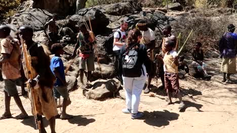Tourists-saying-goodbye-shaking-hands-to-Hadzabe-tribe-people,-Tanzania,-Africa