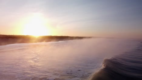 Drohne-überführung-Ozean-Folgen-Wellen,-Die-Während-Des-Sonnenaufgangs-In-Mystischen-Nebel-Gehüllt-In-Richtung-Strandufer-Rollen