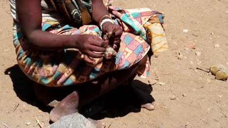 Female-African-tribe-member-plucking-birds-to-cook-and-eat