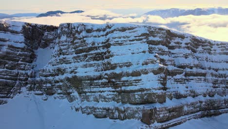 Luftaufnahmen-Einer-Bergkette-In-Den-Spanischen-Pyrenäen,-Bedeckt-Mit-Schnee-Und-Wolken-Am-Horizont