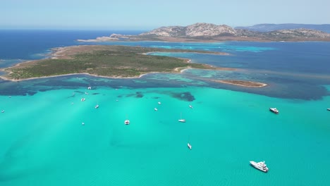 Boats-at-turquoise-blue-sea-during-summer-in-La-Pelosa,-Sardinia,-Italy---4k-Drone-Aerial