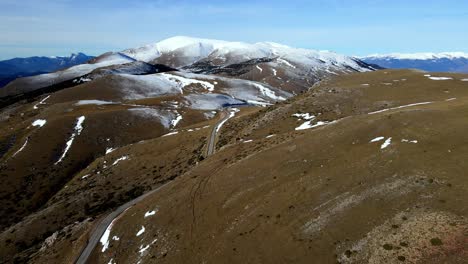 Luftaufnahmen-Einer-Bergkette-In-Den-Spanischen-Pyrenäen,-Bedeckt-Mit-Schnee-Und-Wolken-Am-Horizont