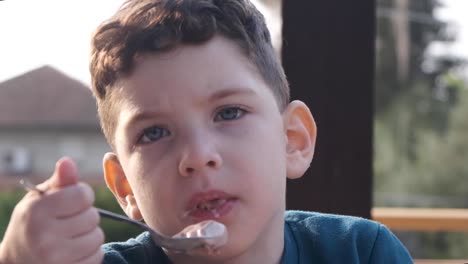 Close-up-of-a-cute-little-boy-enjoying-delicious-ice-cream-during-the-summer
