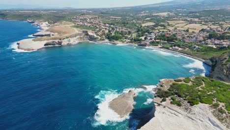S'-Archittu-beach-town-and-rocky-cliffs-along-west-coast-of-Sardinia---4k-Aerial-backwards