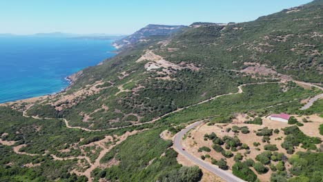 Coastal-Road-at-West-Coast-of-Sardinia-along-Blue-Sea-and-Green-Mountains---4k-Aerial