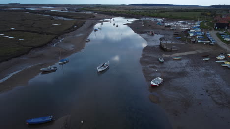 Aerial-Drone-Shot-Flying-Over-Creek-at-Low-Tide-with-Sailing-Boats-in-North-Norfolk-on-Cloudy-Gloomy-Moody-Day-UK