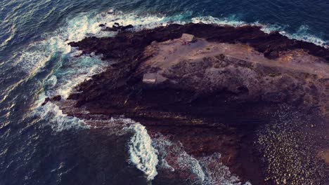 Aerial-Shot-Of-Rocky-Hill-With-Waves-Crashing-All-Around-In-Tenerife,-Spain