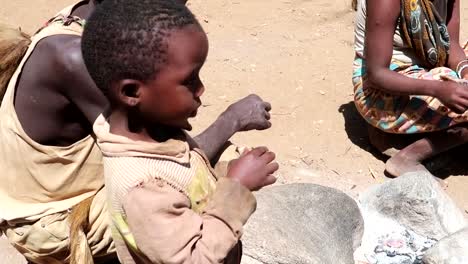 Young-malnourished-family-in-Africa-with-a-small-child-eating-a-bird