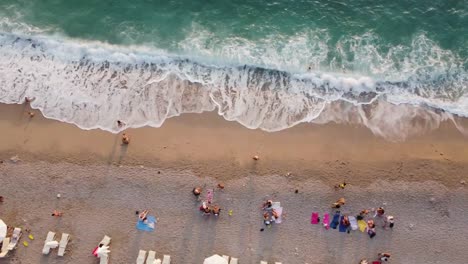 Drone-view-of-People-enjoying-and-resting-on-Kidrak-beach-in-Oludeniz,-Turkey