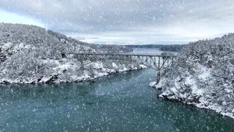 Wide-aerial-view-of-Deception-Pass-in-Washington-State-with-snow-actively-falling