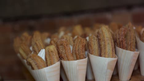 Fried-sugar-coated-churros-for-sale-in-white-paper-cones
