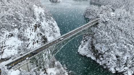 Aerial-view-of-cars-driving-over-Deception-Pass-while-snow-is-actively-falling