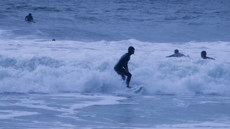 Zeitlupe-Einer-Frau,-Die-An-Bewölkten-Tagen-Im-Meer-Gegen-Den-Himmel-Surft,-Portugal