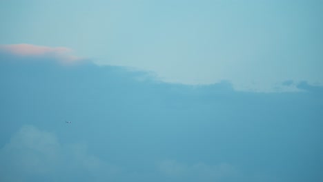 Avión-Volador-En-Un-Cielo-Azul-Oscuro-Escénico,-Nubes-De-Surf,-Video-4k