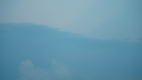 Avión-Volador-En-Un-Tormentoso-Cielo-Azul-Oscuro,-Nubes-De-Surf,-Video-4k