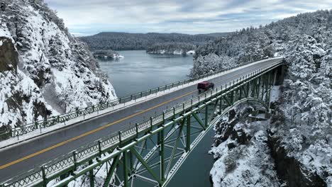 Truck-crossing-a-bridge-with-the-surrounding-land-covered-in-snow