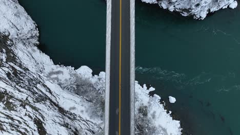 Overhead-aerial-view-of-an-empty-bridge-with-snow-covering-the-land