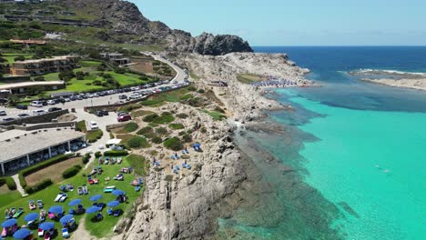 La-Pelosa-Beach-Bar-Restaurant-and-Coastline-during-Summer-in-Sardinia,-Italy---4k-Aerial
