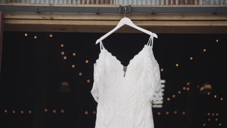 Handheld,-beautiful-white-wedding-dress-hanging-from-a-barn-door
