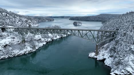 Wide-aerial-view-pulling-away-from-Deception-Pass-with-fresh-snow-on-the-ground