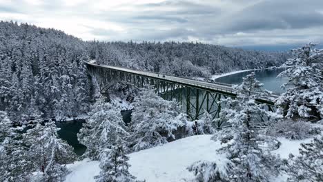 Drone-shot-flying-up-and-over-Deception-Pass-bridge-with-snow-covering-the-ground